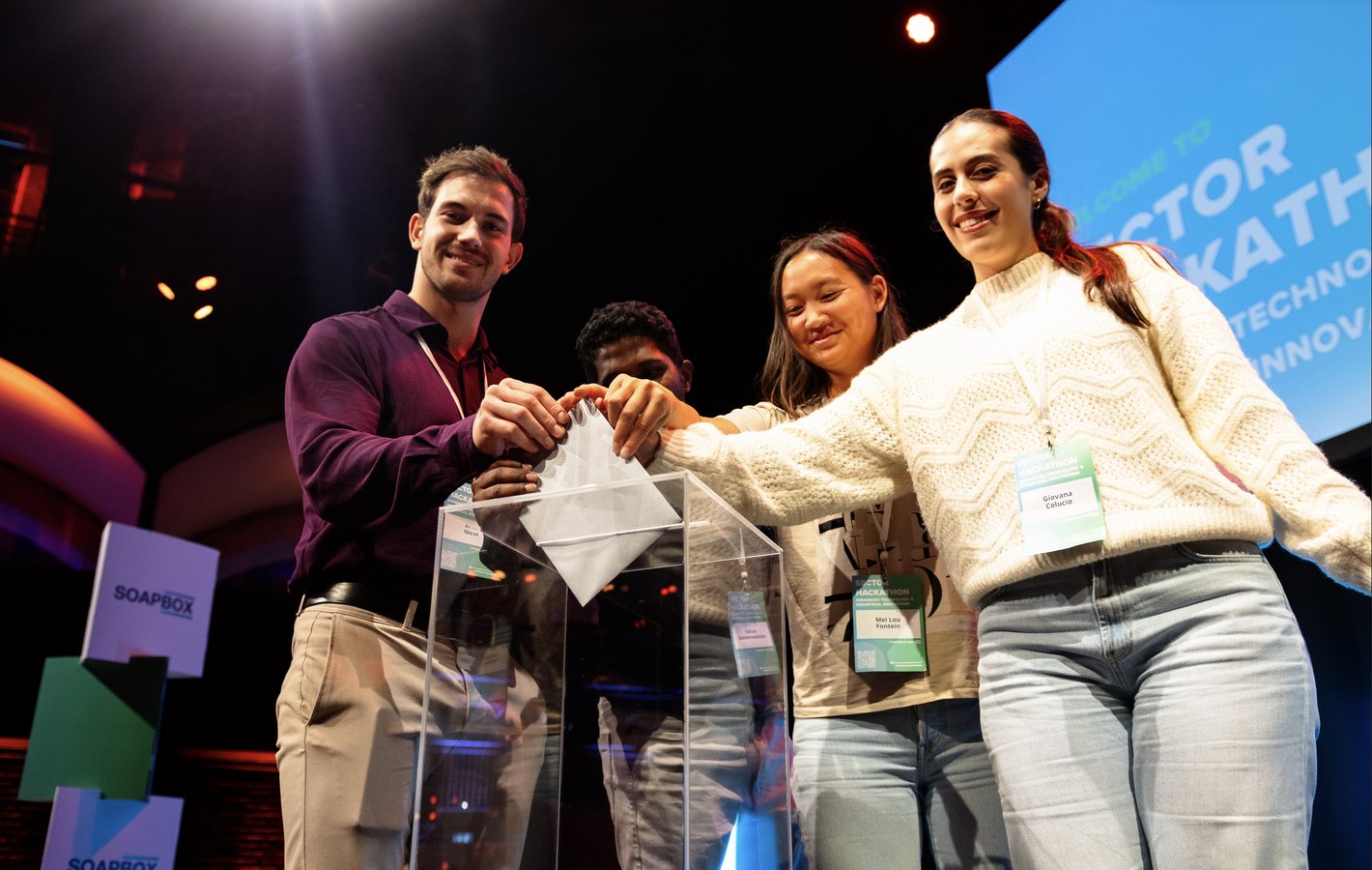 Participants of the Soapbox hackathon presenting innovative ideas together during a team activity in a dynamic and creative environment.